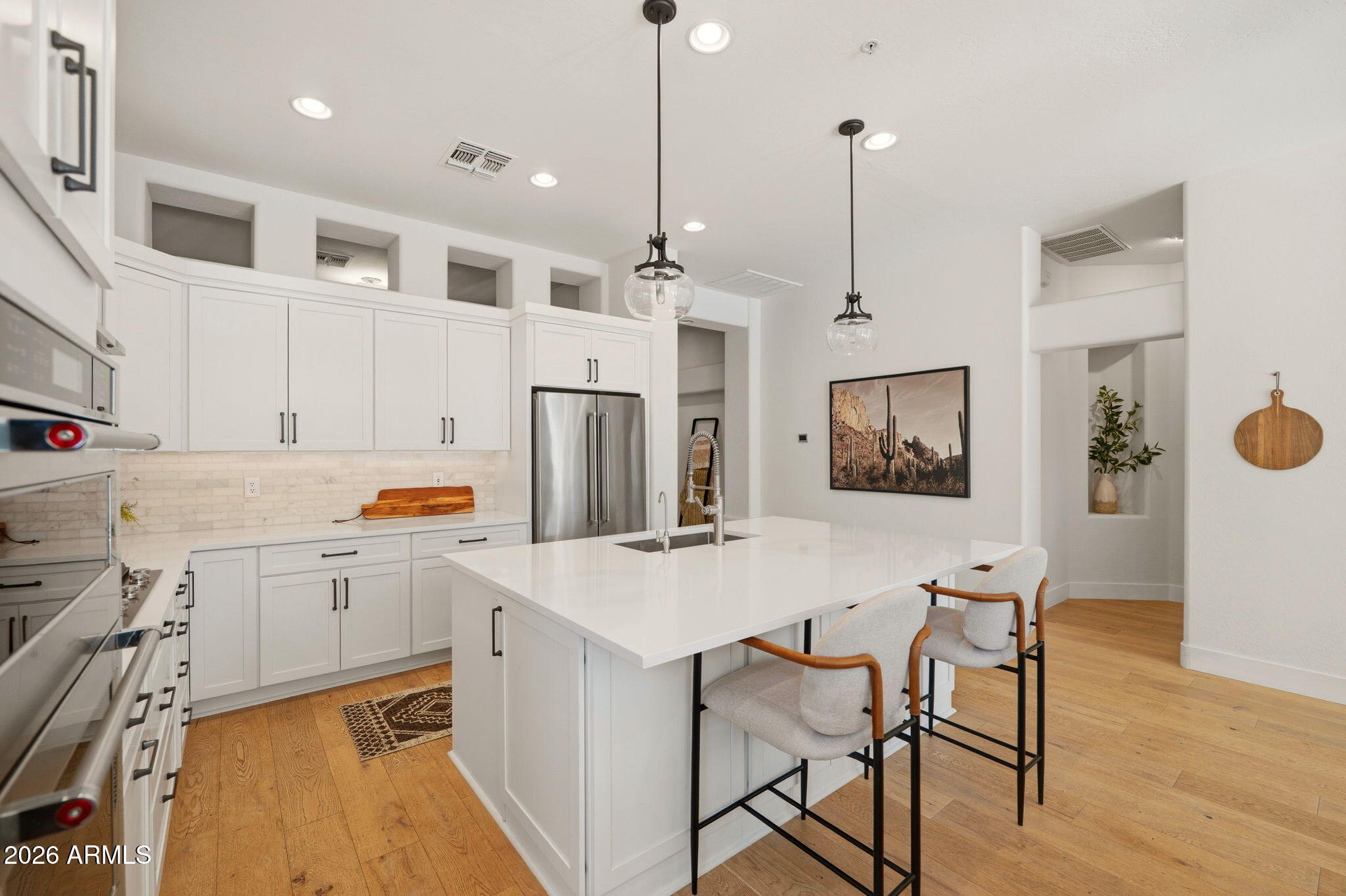 Kitchen with quartz waterfall island, pendant lighting, and bar seating at 9155 E Rusty Spur Pl