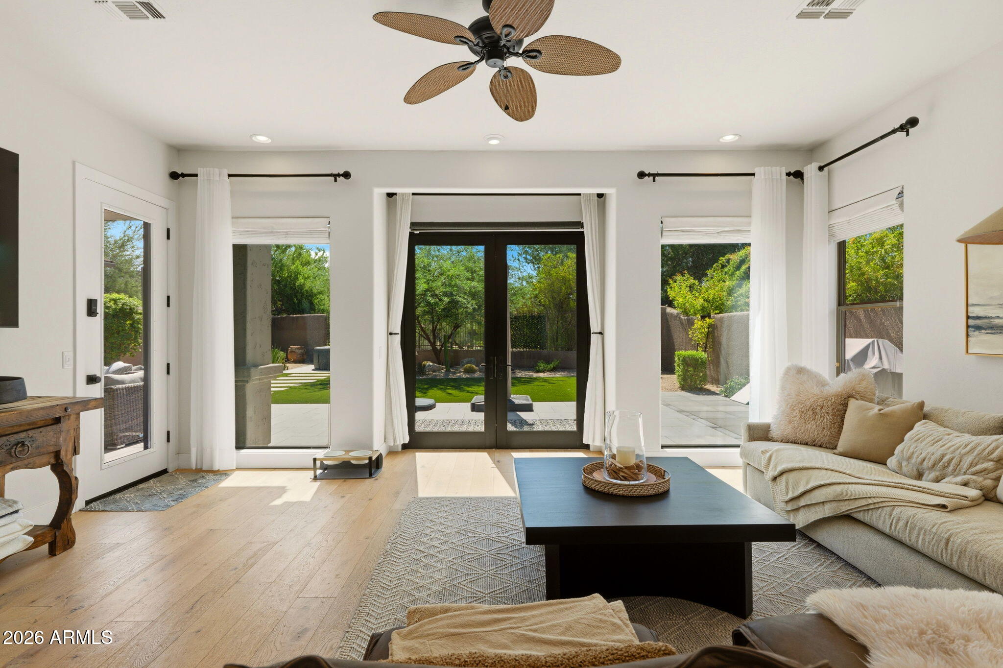 Living room with ceiling fan and French doors opening to the back patio