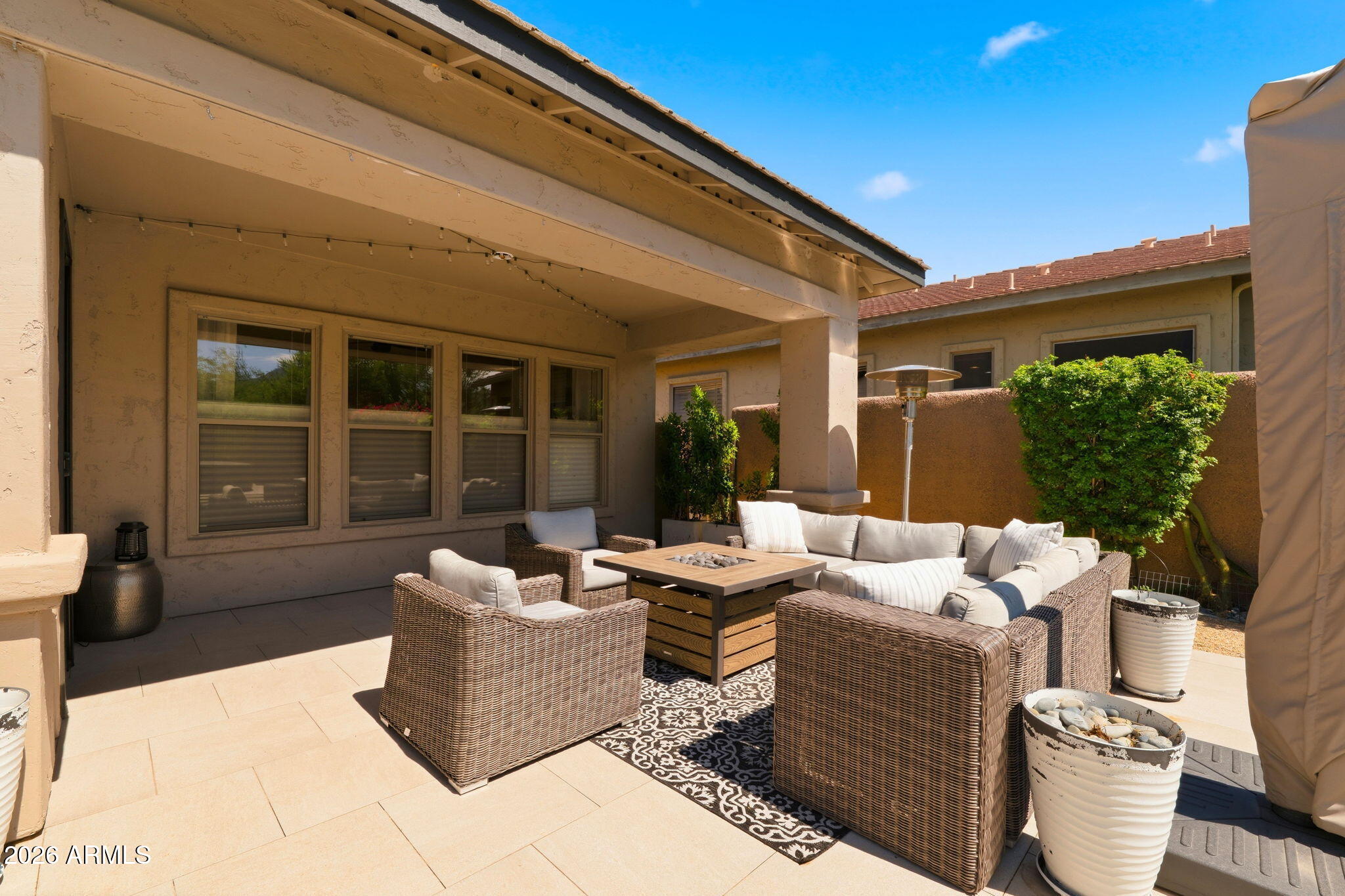 Covered rear patio with lounge seating and fire table